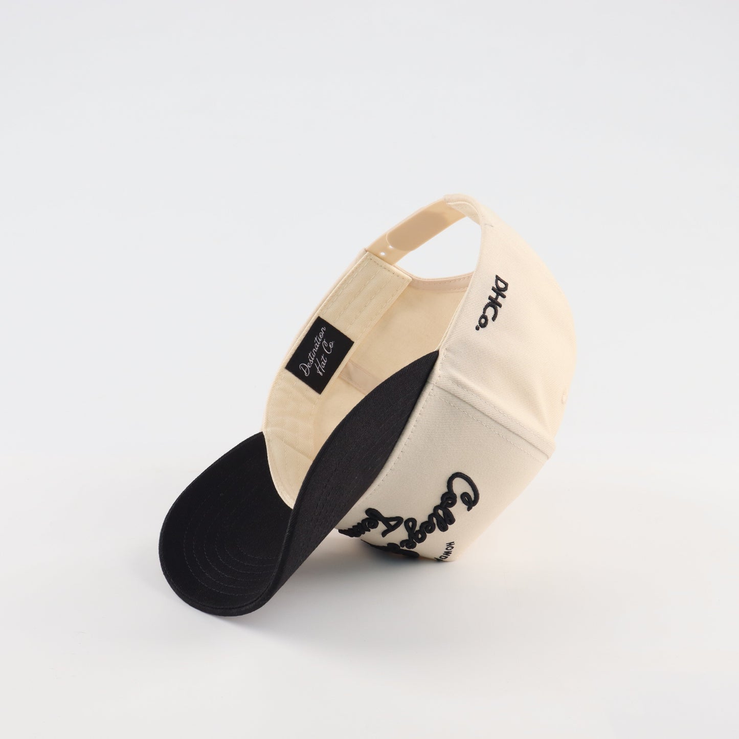 College Station Script Beige and Black Pre-curved Trucker Hat Destination Hat Co.