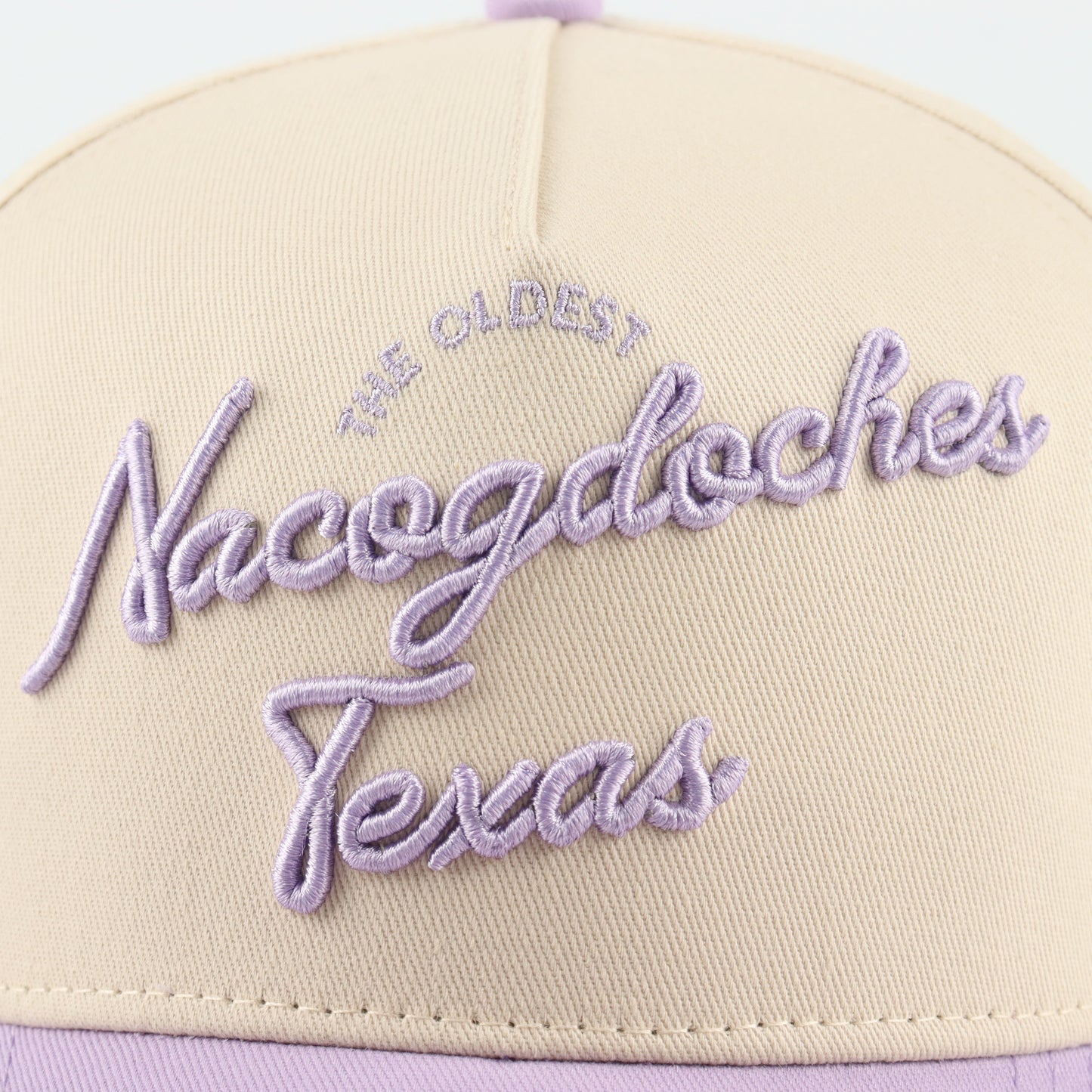 Nacogdoches Script Beige and Purple Pre-curved Trucker Hat